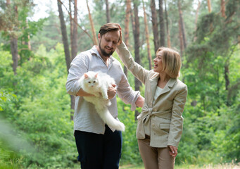 Fototapeta premium couple spending time together outdoors with a cat