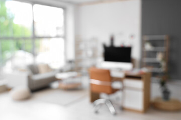 Blurred view of office with interior designer's workplace and sofa