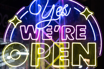 Neon light Yes we're open sign night festival pink yellow