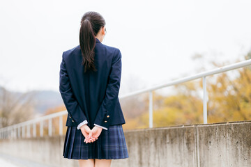待ち合わせする女子高生の後姿（顔なし）
