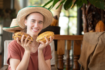 German girl with tropical fruit holding, cocoa fruits, in local cafe and drinks shop.