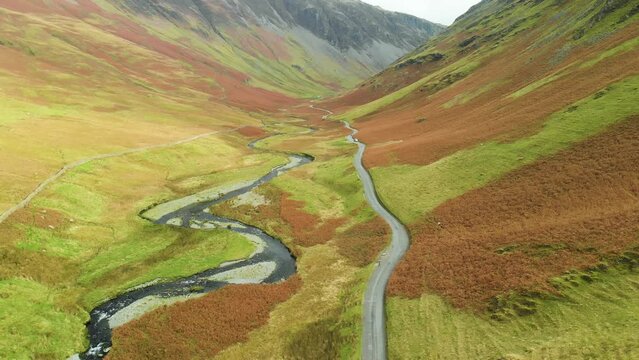 Aerial view of Honister Pass, a mountain pass with a road winding along Gatesgarthdale Beck mountain stream. One of the steepest and highest passes in the region. Cumbria, the Lake District, England.