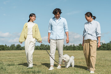 犬・ペットと遊ぶ家族・ファミリー（両親と子供・3人） 