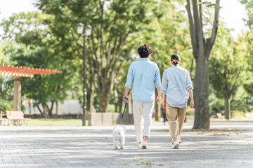 犬の散歩をする夫婦・愛犬家・飼い主・ペットシッター・家族
