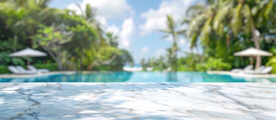 White marble table top with blurry tropical resort pool background, perfect for displaying products or creating montages.