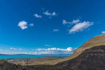 A beautiful blue sky with a few clouds and a mountain in the background