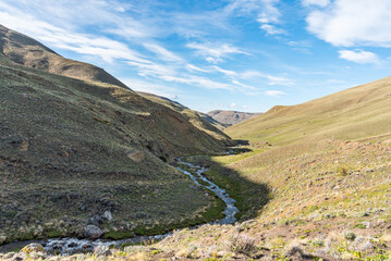 A valley in patagonian steppe with a river running through it with meltwater