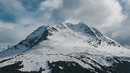 A snow-covered mountain beneath a cloudy sky.