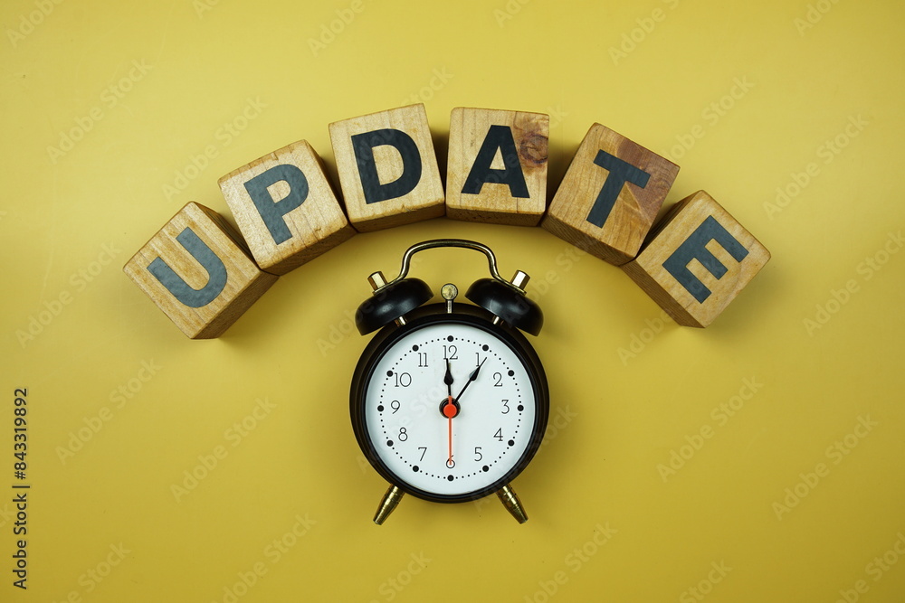 Poster update word and alarm clock top view on yellow background