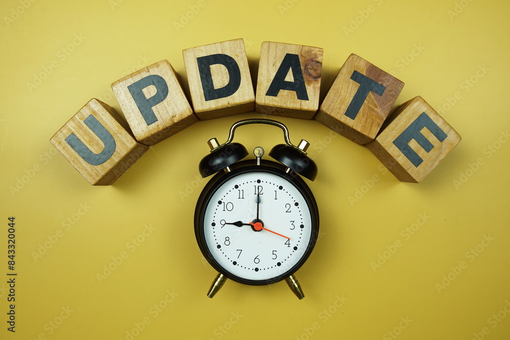 Poster update word and alarm clock top view on yellow background