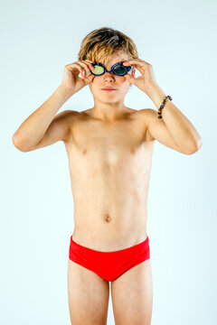 Youth male competitive swimmer athlete adjusting his swimming goggles before a swim meet