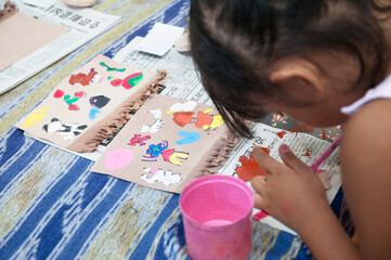 絵画教室でカラフルな絵の具で絵を描く小学生の子ども