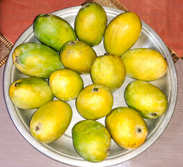 Mango in a bowl, a bowl of mangoes, a bowl of ripe mangoes is shown on a table,