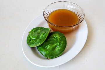 stale Pandan green Surabi (Indonesian pancake) served with a side of palm sugar syrup