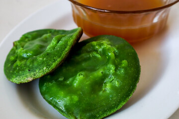 stale Pandan green Surabi (Indonesian pancake) served with a side of palm sugar syrup