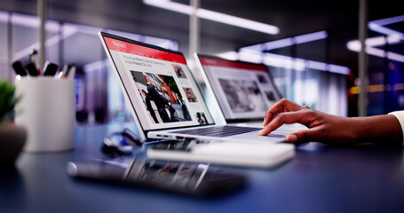 American Woman Views Online News Articles on Laptop and Phone While Relaxing