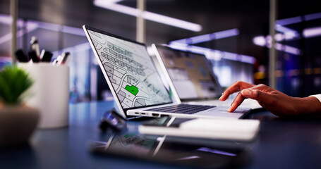 African American woman closely examining cadastral map on laptop screen