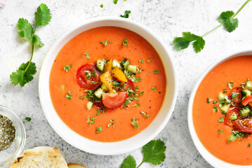 Delicious gazpacho soup in bowl over light stone background