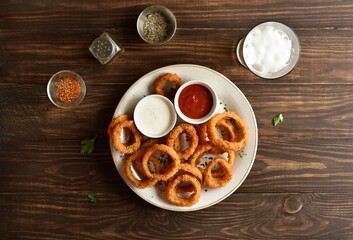 Fried breaded onion rings served with sauce