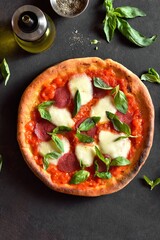 Pizza with mozzarella, pepperoni, tomato sauce and basil