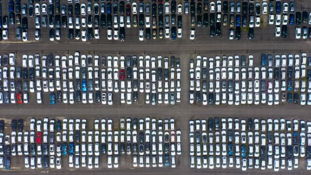 Top down view of a giant parking lot with new cars. New automobiles storage facility car industry for export all over the world market for car sales. 