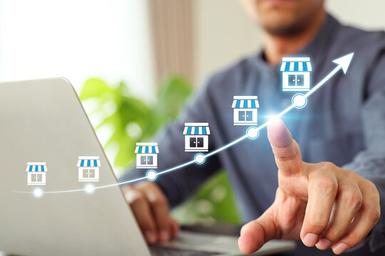 Hand choose franchise business store on arrow graph for franchising goal to growth branch expansion and business banking loan or consumer resources service.