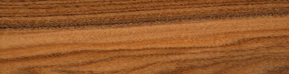 Rich, textured santos rosewood or palisander wooden surface showcasing natural patterns and warm tones. Panoramic wood veneer texture.