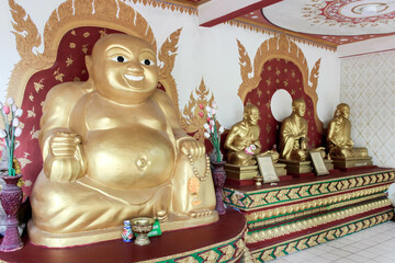 The temple showcases majestic golden Buddha statues with intricate designs and sacred offerings
