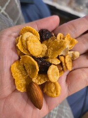 hand holding a plate of dried fruits