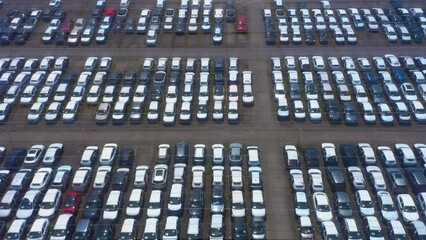 Top down view of a giant parking lot with new cars. New automobiles storage facility car industry for export all over the world market for car sales. 
