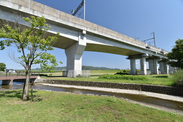 Fototapeta premium 線路と小川と橋のある公園の風景