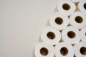 Pile of white toilet papers on a shelf in a white bathroom.