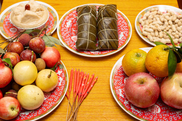 table with Zongzi and various fruits and a cake and peanuts as traditional offerings for the Dragon Boat Festival