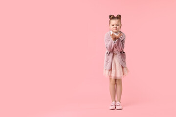 Cute little girl dancing on pink background, space for text