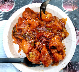 Image of Veg Manchurian Momos garnished in a disposable plate