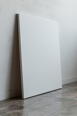 Blank canvas mockup on laminate floor against white wall for creative inspiration