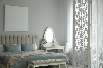 Folding screen, mirror and comfortable bed in bedroom. Interior design