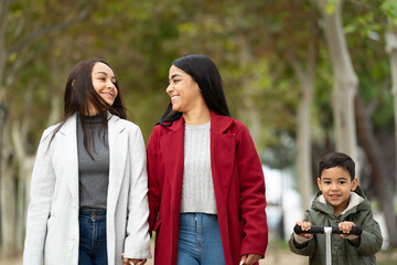 Front view of lesbian latin family spending time together in a park .LGBT family