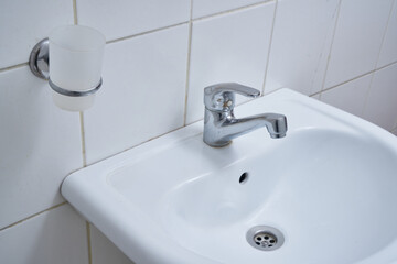 A water faucet in a white bathroom. 