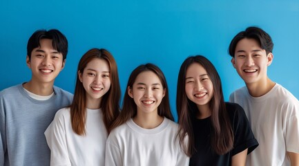 A portrait of korean young people early twenties. standing close together against an isolated blue background. They wear casual t-shirts or hoodies, exuding youthful happy energy. generative AI
