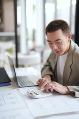 Attractive confident millennial Asian Business man using laptop computer and professional working investor start up project business planning in office.