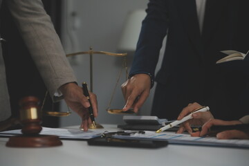 Judge gavel with Justice lawyers having team meeting at law firm background. Concepts of Law and Legal services.