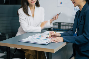 Businesswoman team or financial data analysts working with tablets and laptop computers and data...