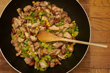 Chinese fried chicken with vegetables in wok frying pan