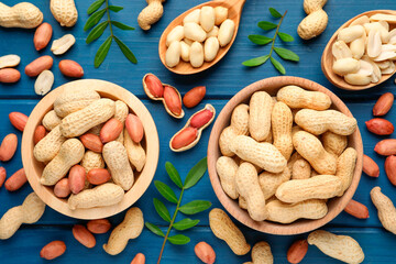 Fresh peanuts and twigs on blue wooden table, flat lay