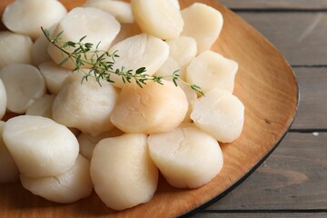 Fresh raw scallops and thyme on wooden table, closeup
