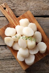 Fresh raw scallops and thyme on wooden table, top view