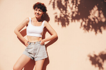 Young beautiful smiling hipster woman in trendy summer shorts and top white t-shirt. Carefree woman...