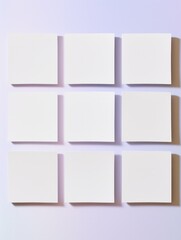 Fototapeta premium Nine evenly spaced blank white canvases against a purple wall give a sense of gallery-ready potential