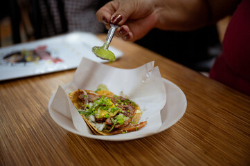 Mexican woman eating tacos al pastor, mexican food in Mexico Latin America